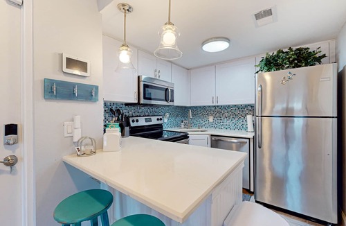 Cape Caneveral Beach Gardens Condo | Pristine condo with shared pool, hot tub, and balcony with partial ocean view