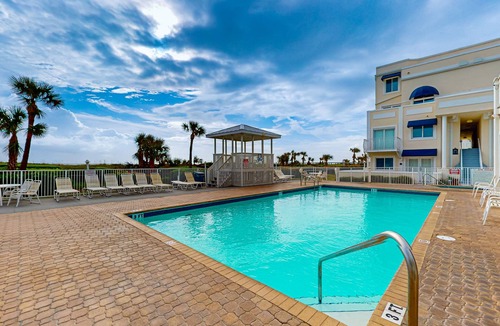 Cape Caneveral Beach Gardens Condo | Pristine condo with shared pool, hot tub, and balcony with partial ocean view